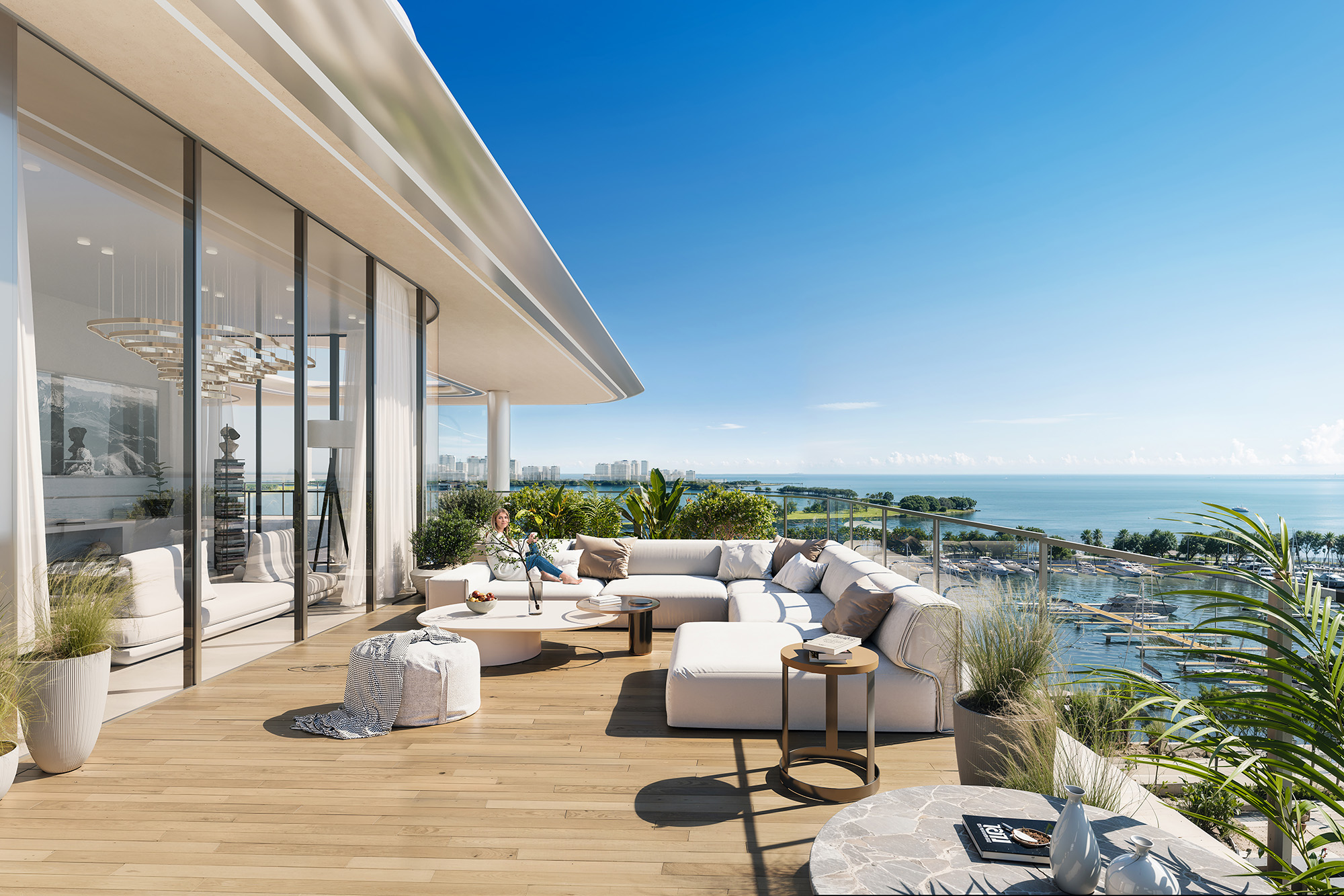 Cotier House By Imtiaz A stylish balcony featuring modern white furniture, greenery, and a scenic ocean view under a bright blue sky.